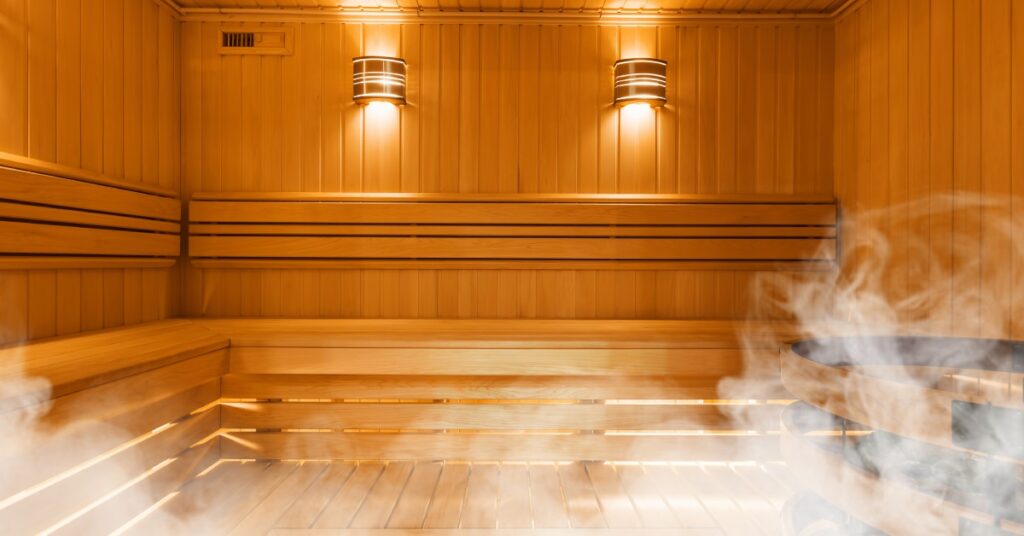 The interior of a traditional wooden, Finnish sauna. The room is made of a wooden planks with steam coming from below.